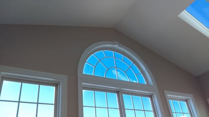 Tall arched window with fresh interior wall paint and white trim