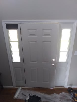 Freshly painted entry door with sidelights and white trim